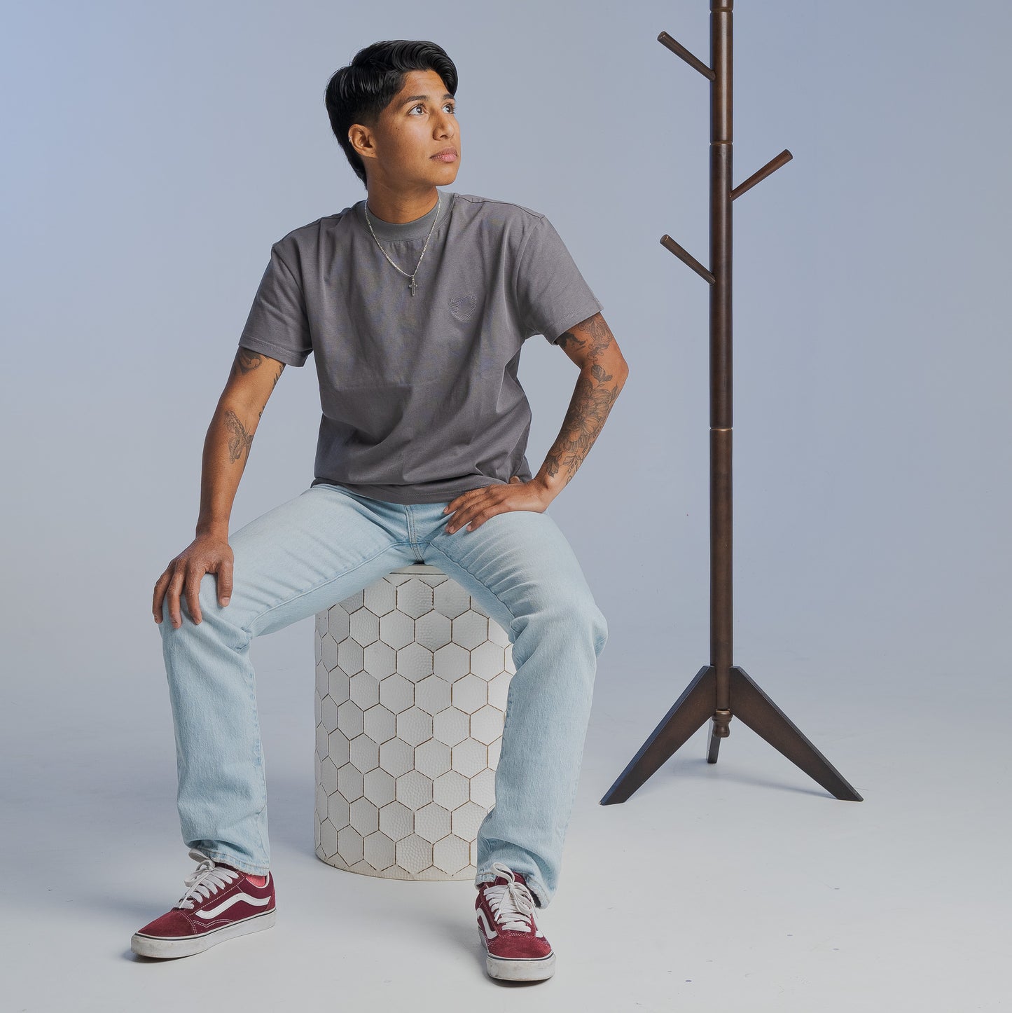 Bro Code LGBTQIA+ inclusive t-shirt worn by person sitting on hexagonal stool with casual jeans and red sneakers